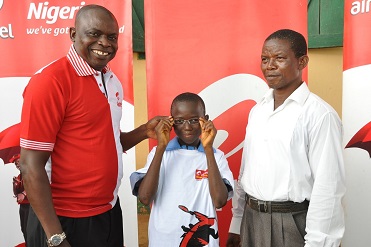 (L-r): Akinsola Omoniyi, area business manager, Airtel Nigeria, Lagos North,   a primary six pupil of St. John’s Primary School with Mr. Adewale Oladele, the head teacher, during the presentation of eye glasses to pupils of the school in Oke-Agbo, Ijebu-Igbo, Ogun State